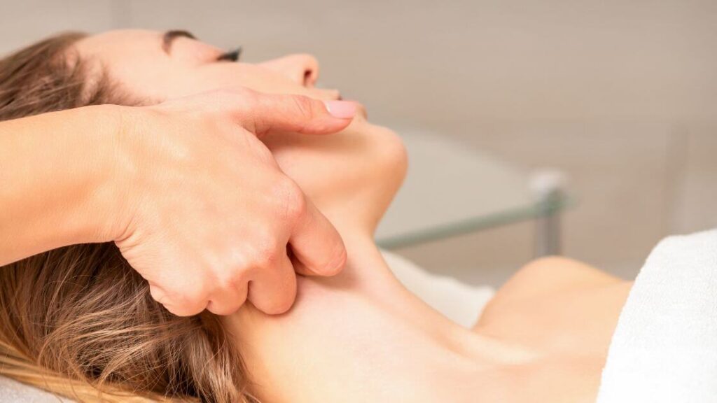 Ultimate Guide to Lymphatic Drainage Massage: Techniques, Benefits, and Precautions 4 A massage therapist performing manual lymphatic drainage techniques on a patient's upper body