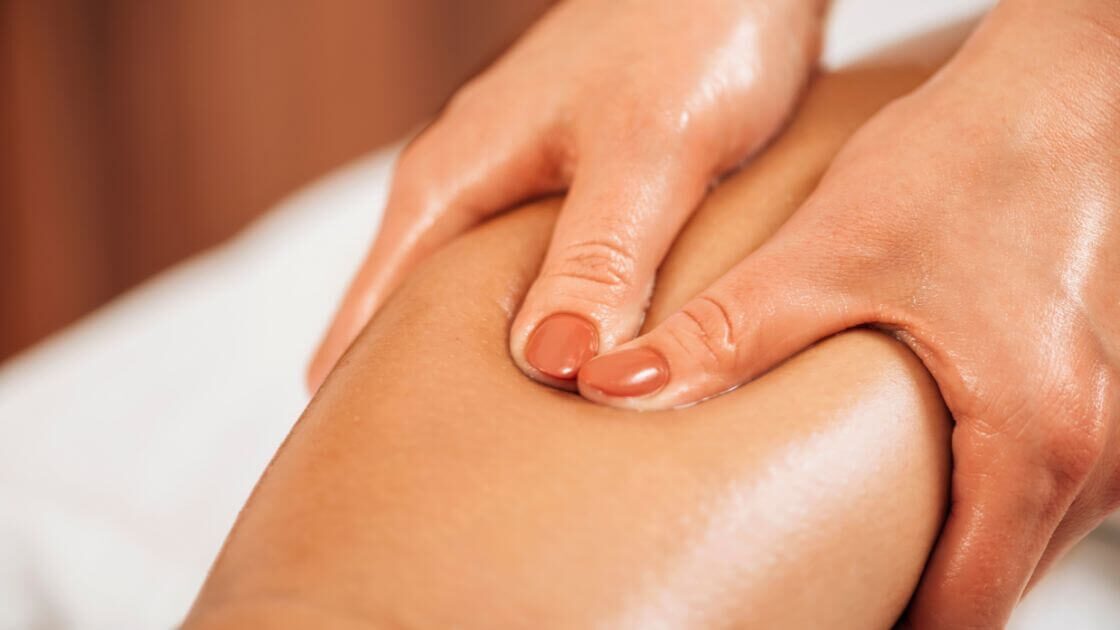 A massage therapist performing lymphatic drainage massage on a patient