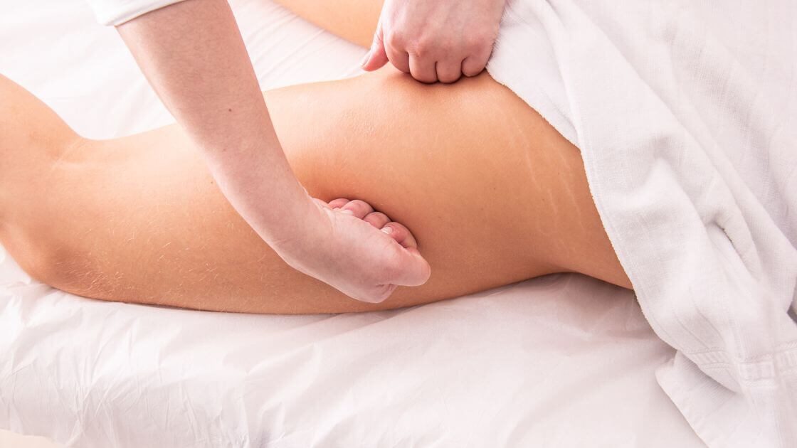 A massage therapist performing lymphatic drainage massage on a patient to address common misconceptions